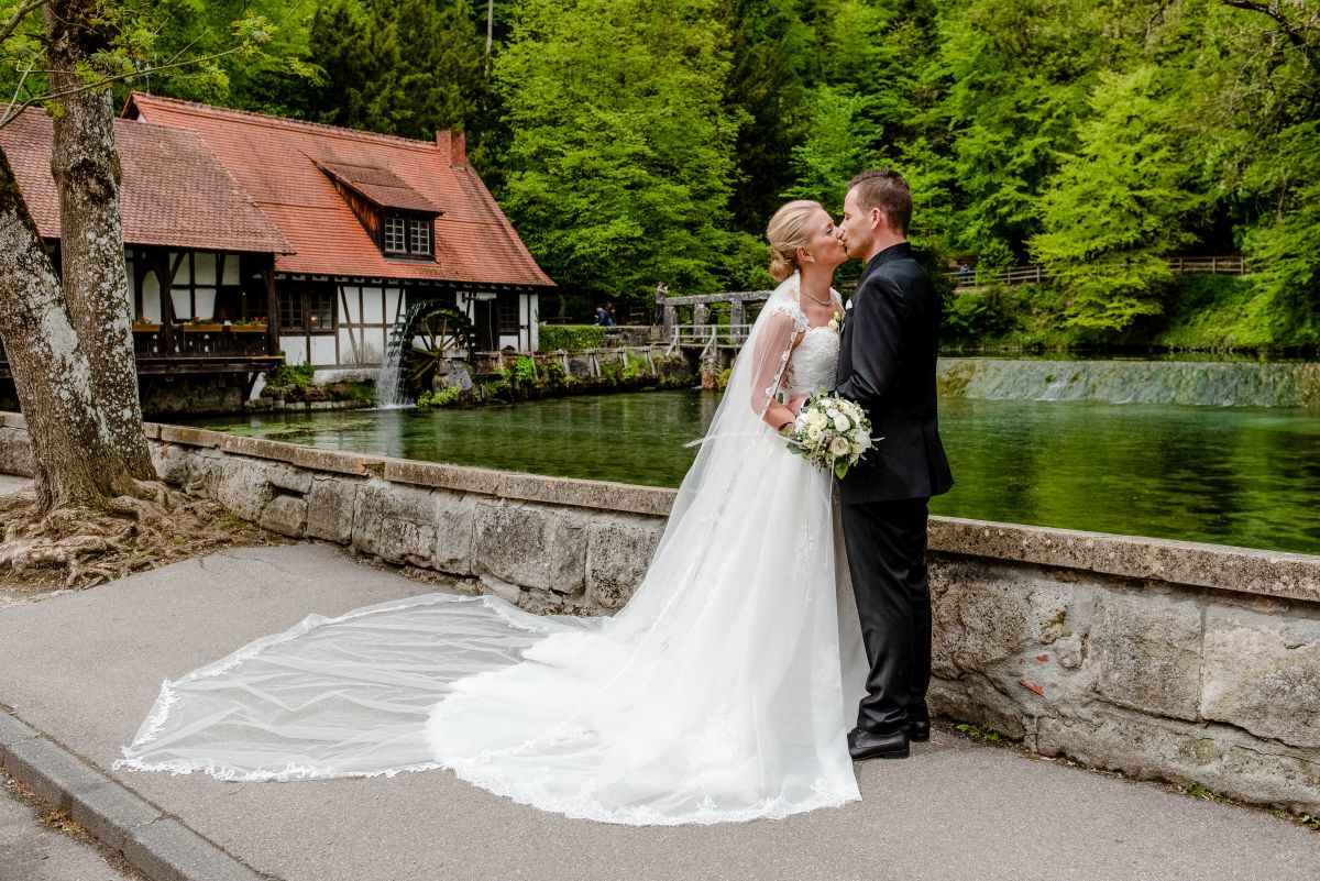 Brautpaar küsst sich am Blautopf in Blaubeuren